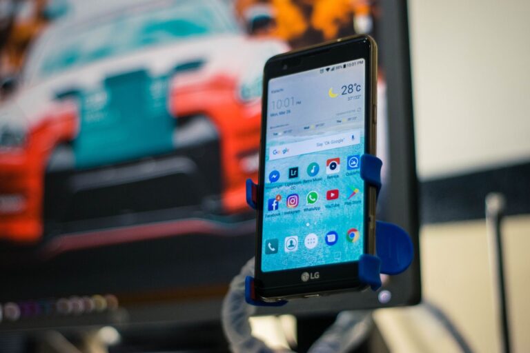 Smartphone mit Carsharing-App neben einem Auto