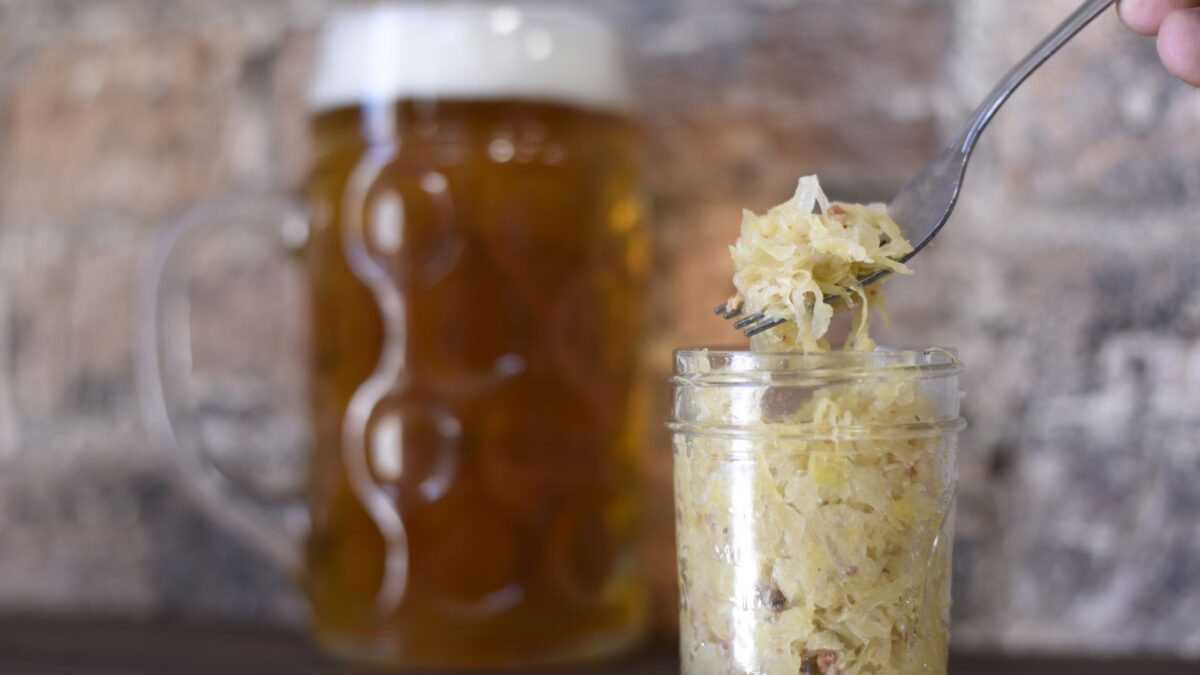 A rustic setting featuring a frothy beer mug and sauerkraut in a jar, perfect for pub themes.