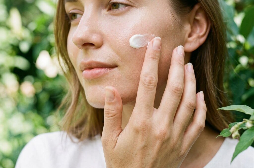 Frau trägt natürliche Sonnencreme im Gesicht auf