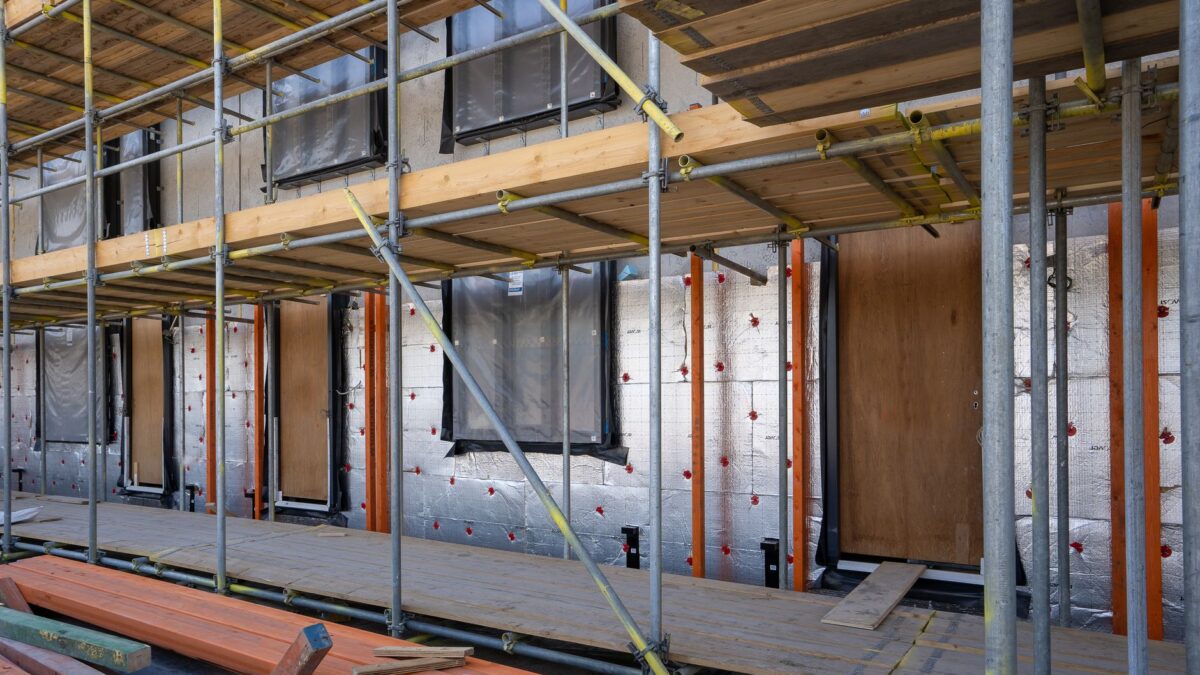 Handwerker bei Dämmarbeiten an der Fassade eines Wohnhauses